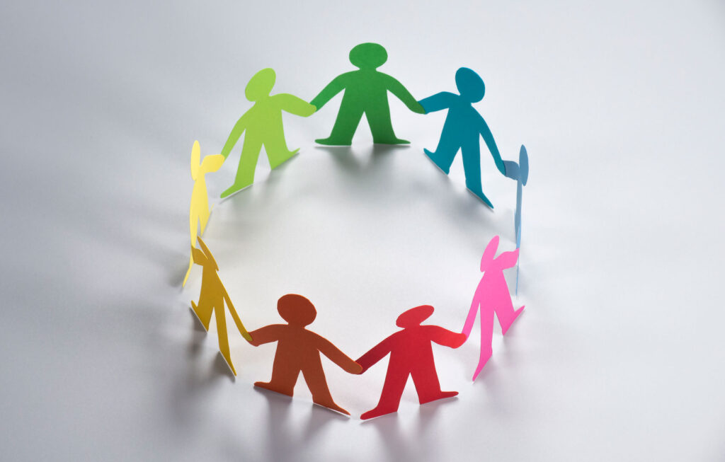 group of paper dolls in circle form holding hands